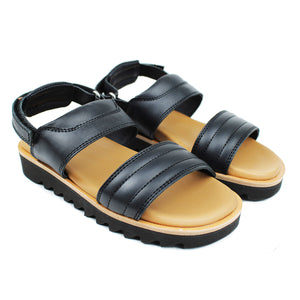 Sandals in black leather and chunky shark tooth soles