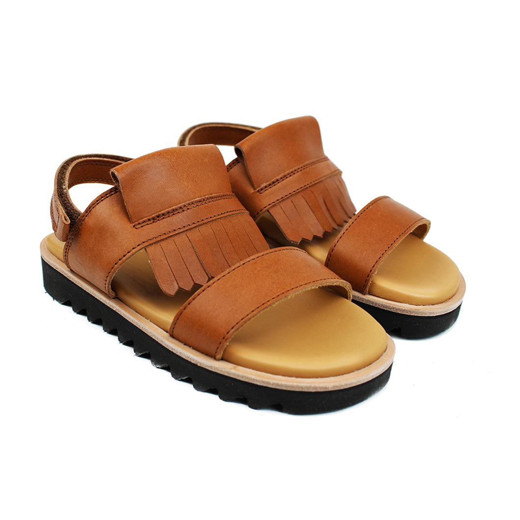 Sandals in tan leather, bold fringe and chunky shark tooth soles